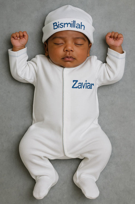 Baby in a white and baby blue footie and hat with embroidered names. Baby in coming home outfit with name.